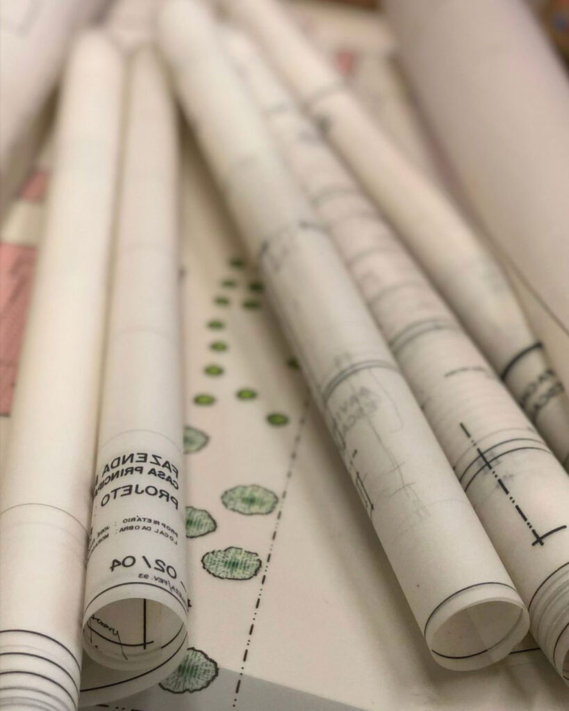 Desenho técnico a nanquim em papel vegetal com linhas finas e traçado preciso sobre prancheta.