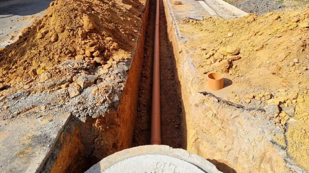 Obra da Sanepar com instalação de tubulações e estruturas de saneamento em área urbana do Paraná.