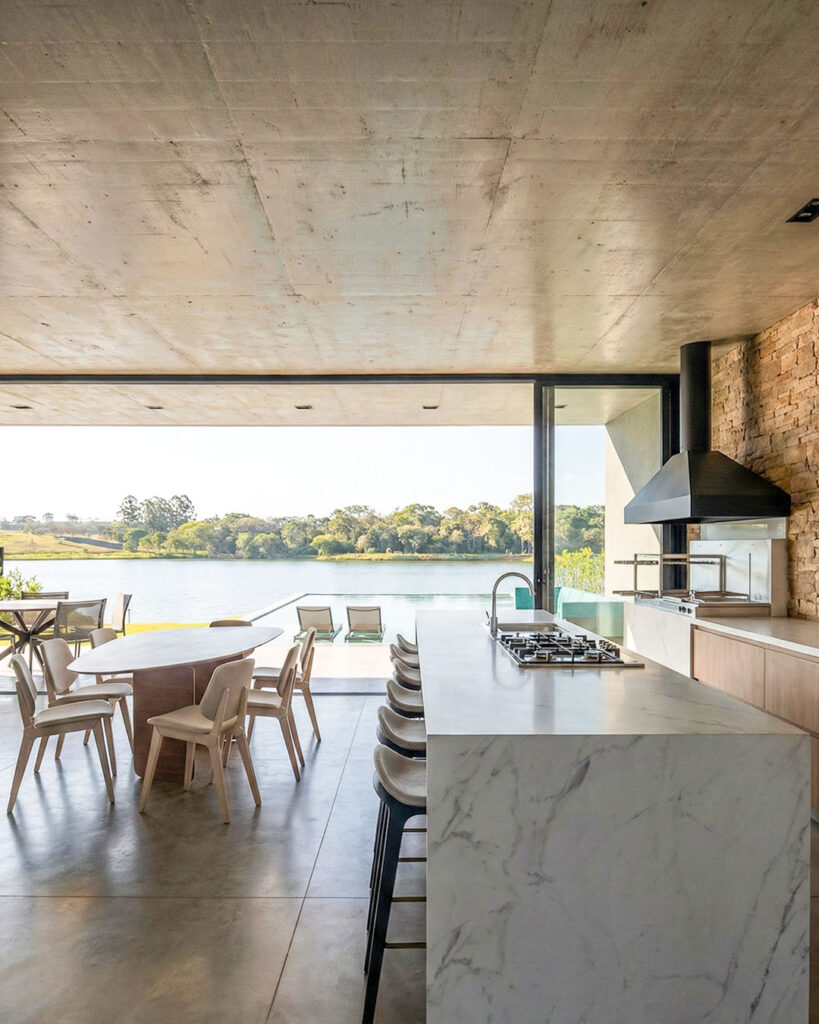 Interior da casa de alto padrão em Uruaçu, Goiás, 2025, com materialidade natural e iluminação projetada.